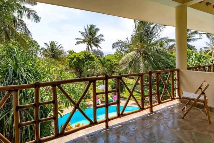 a balcony with a view of the ocean and palm trees at Villa La Diani in Diani Beach