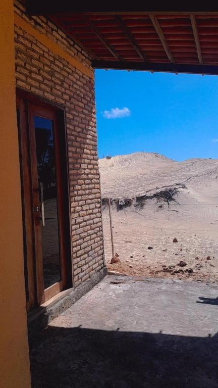 een open deur naar een bakstenen gebouw in de woestijn bij Casa dunas in Guajiru