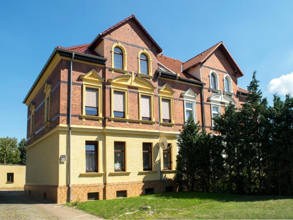 a large house on a grassy field in front at Haus zur Pulvermühle in Zwenkau