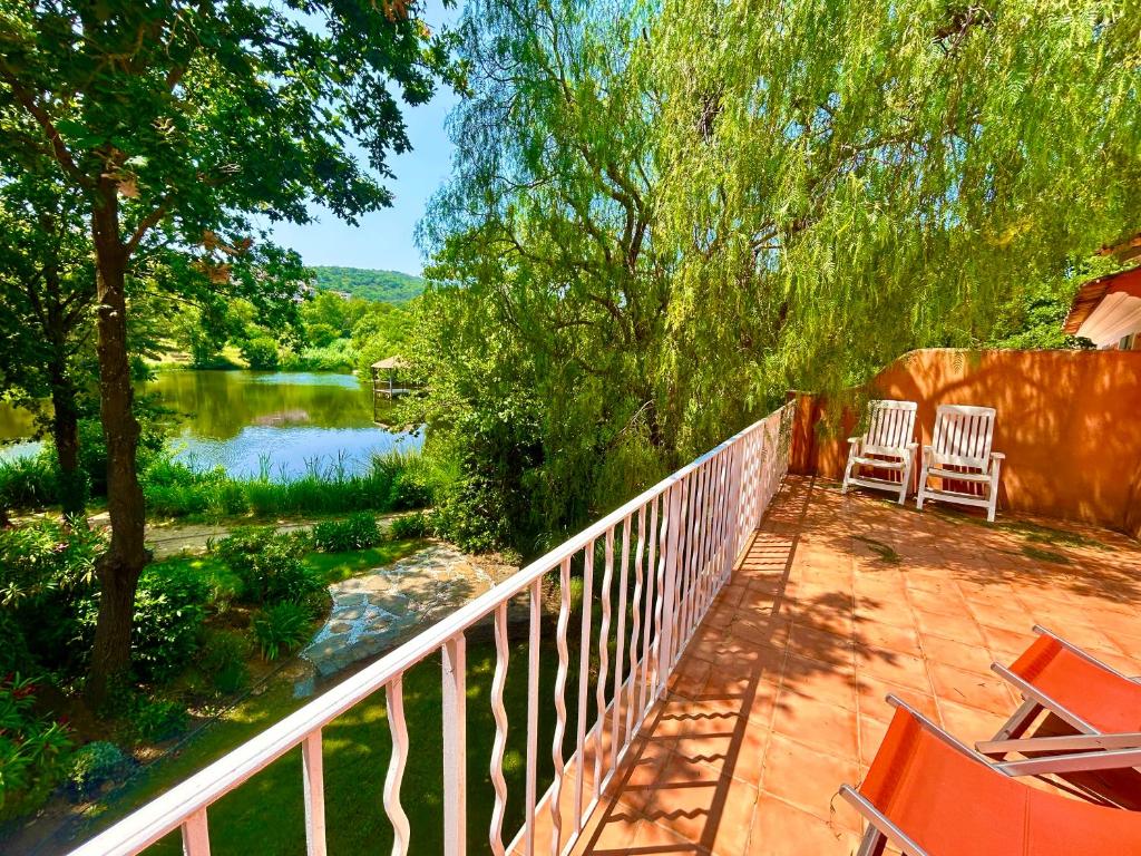 a balcony with two chairs and a river at Les Restanques Maison 12 Lac in Grimaud