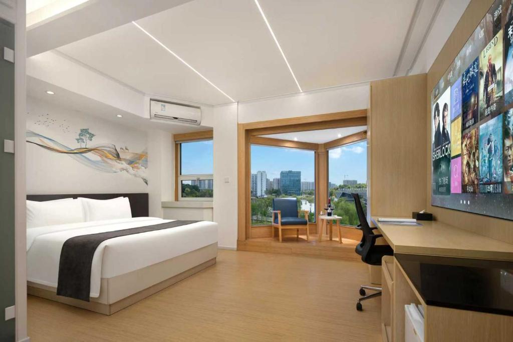 a bedroom with a bed and a flat screen tv at JC Jinchen Lakeview Hotel in Gutang