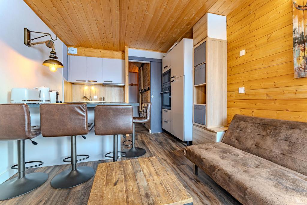 een woonkamer met een bank en een keuken bij Cosy 5 persons / Ski In Ski out in Val Thorens