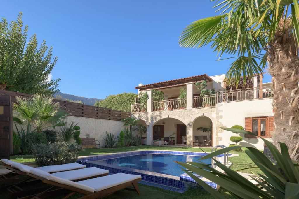 een villa met een zwembad en een huis bij Nicole Villa I "Free" Heated Pool, Village Escape in Embrósneros