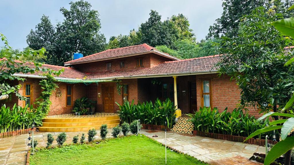 a house with a garden in front of it at Green Roots Farm Stay, Shahapur in Shāhāpur