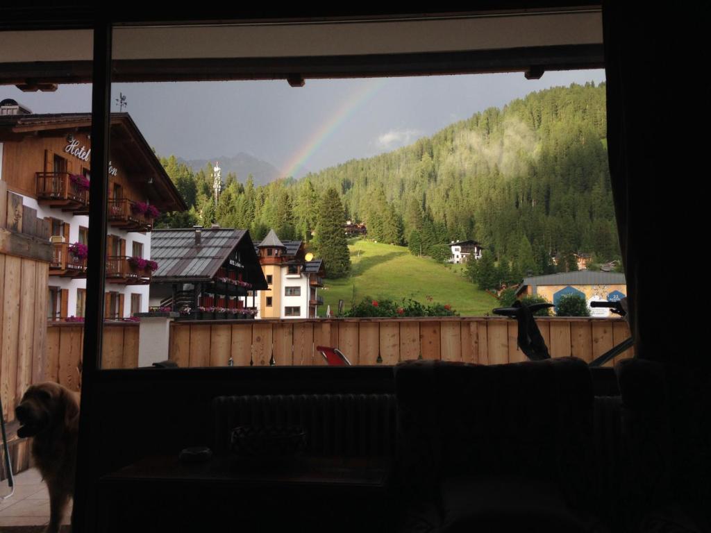 a view of a rainbow from a window with a dog at Residenza Grazia in Madonna di Campiglio