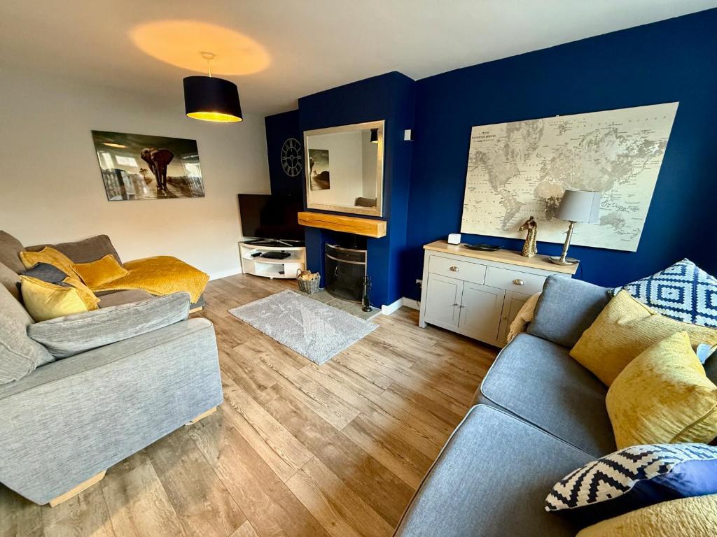 a living room with a couch and a map on the wall at Oak View - Spacious 3 Bedroom House near Oxford and the Cotswolds in North Leigh