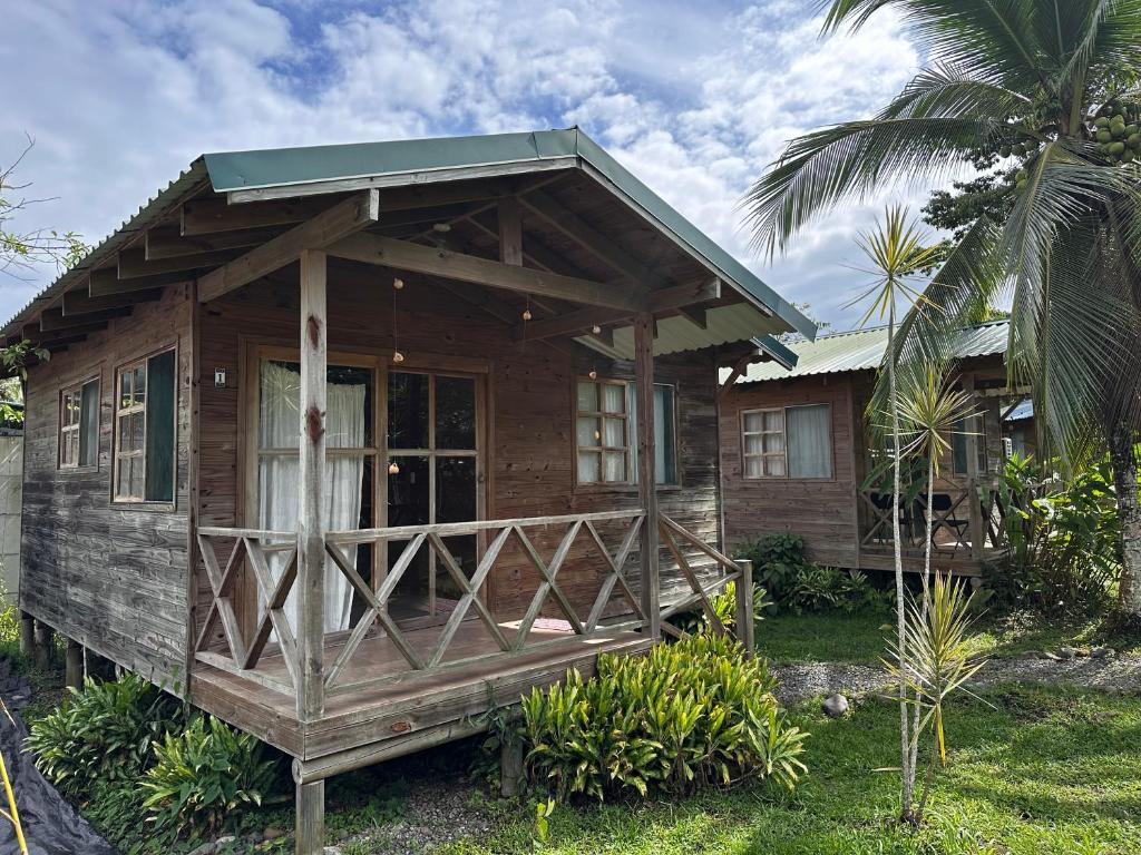 een klein houten huis met een groen dak bij Bobinsana INN in Puerto Limón