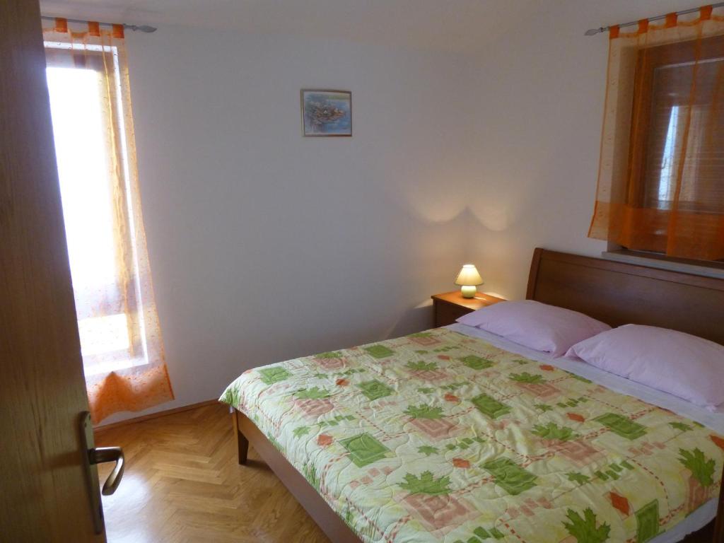 sypialnia z łóżkiem z kwiecistym kocem w obiekcie Apartment Grozic w mieście Porat