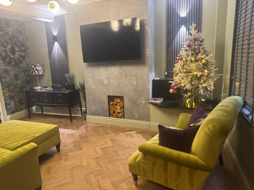 una sala de estar con un árbol de Navidad y una chimenea en NEW Refurbished 2025 Cottage Sleeps 6 Ashbourne Peak District Derbyshire, en Ashbourne