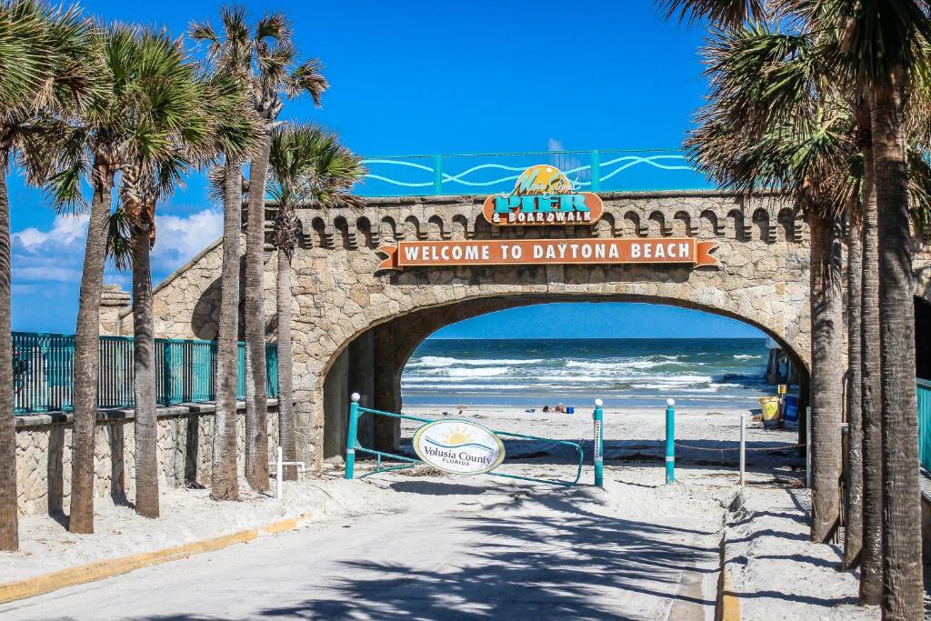 a bridge over the beach with a sign that reads welcome to dolphin beach at Daytona Beach in Daytona Beach