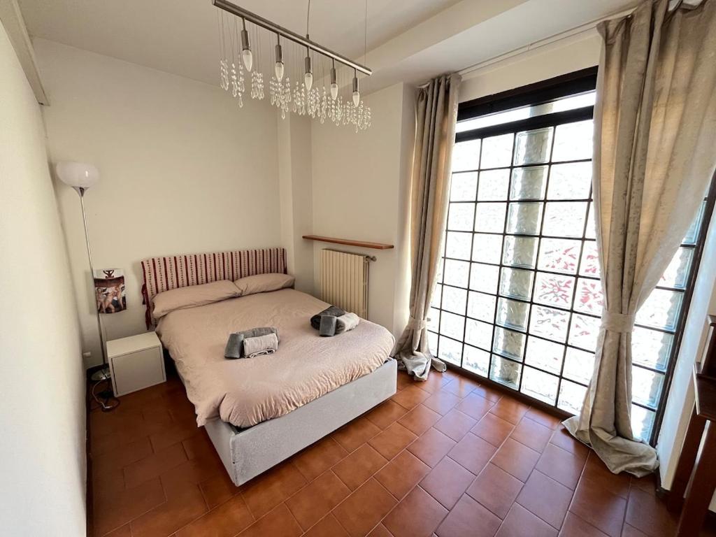 ein Schlafzimmer mit einem Bett und einem großen Fenster in der Unterkunft Luminoso appartamento in pieno centro città NUOVO! in Belluno