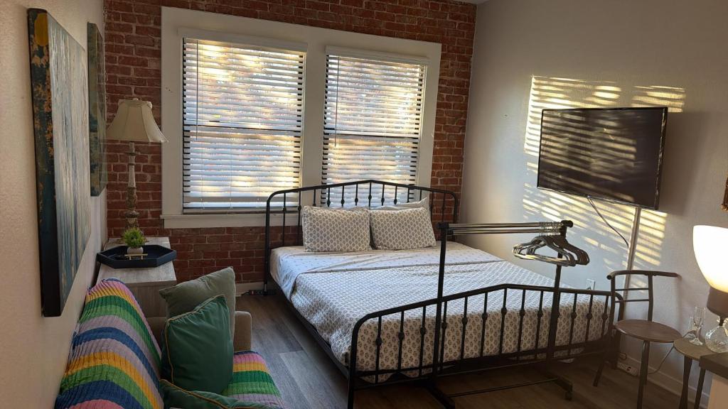 een slaapkamer met een bed en een bakstenen muur bij Popular Hollywood Studio at GW in Los Angeles