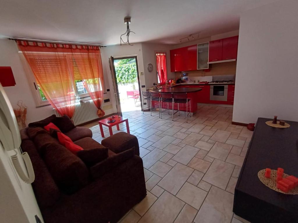 a living room with two couches and a kitchen at Casina Rossa in Ballabio