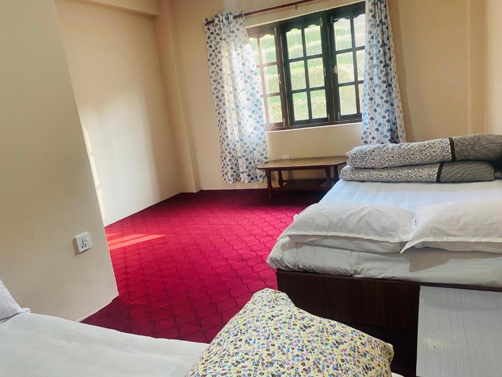 una habitación con tres camas y una ventana en Bhaktapur Yog Homestay, en Bhaktapur