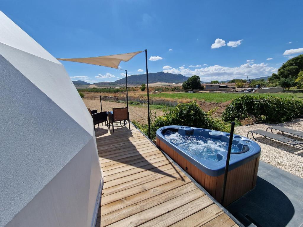 a hot tub on a wooden deck next to a table at Nyxia Dome in Caravaca de la Cruz