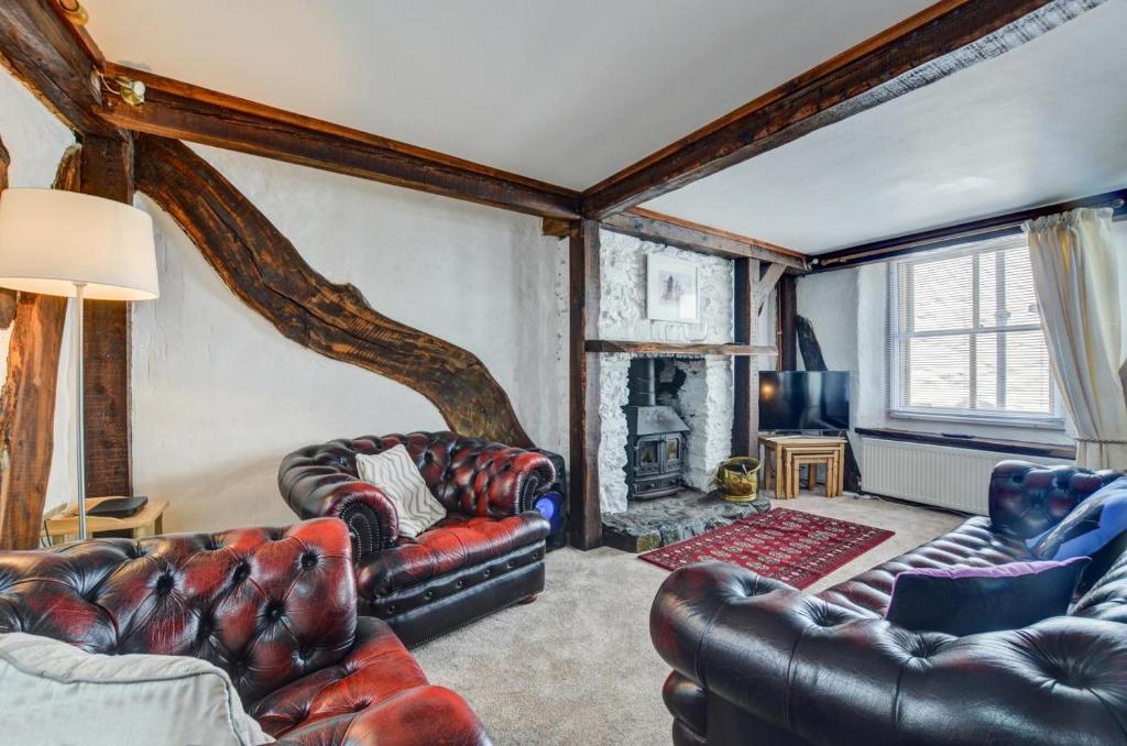 a living room with leather furniture and a fireplace at 4 Bed in Looe oc-l30047 in Looe