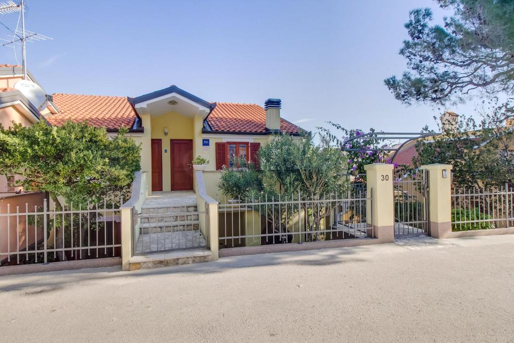 a house with a gate and a fence at Adriana Apartment in Mali Lošinj