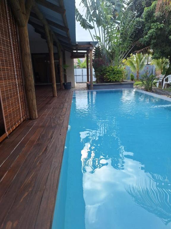 a blue swimming pool with a wooden deck at 1 Bedroom Apartment on ground floor with access to swimming pool in Rose Hill