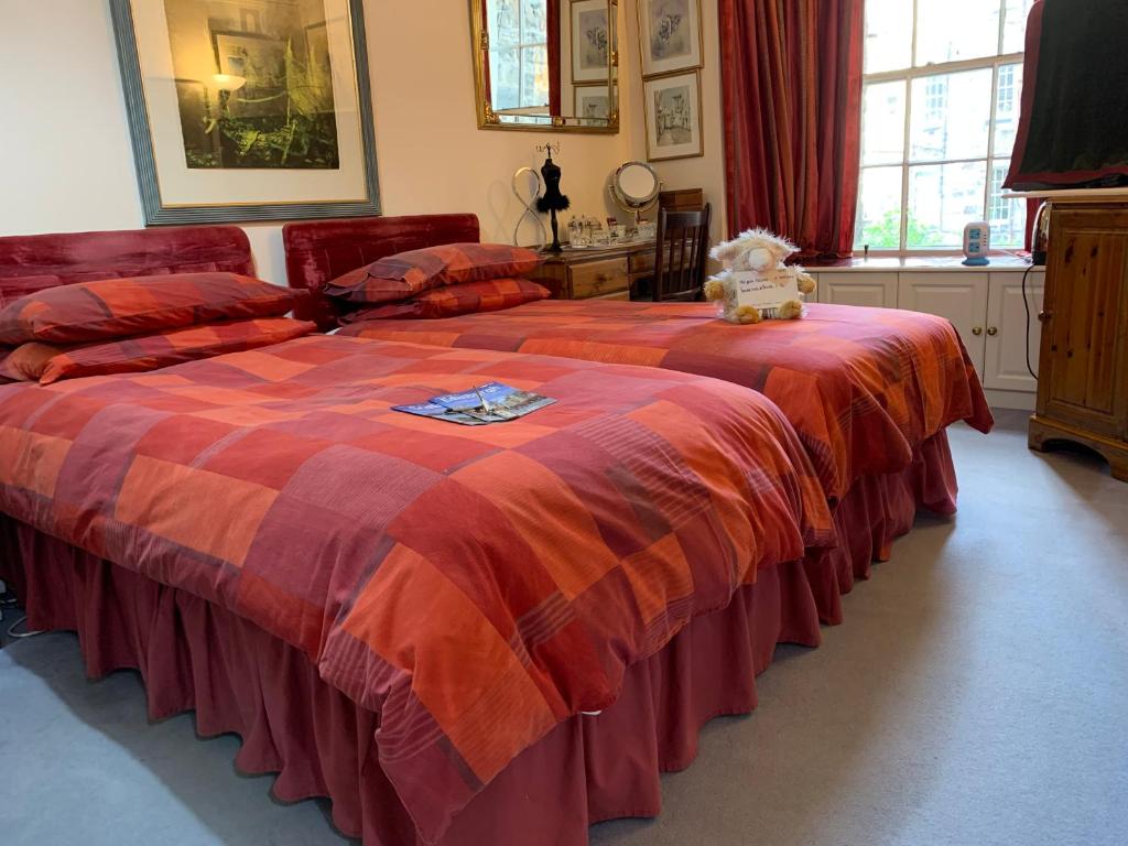 een slaapkamer met twee bedden en een teddybeer bovenop bij Geraldsplace in Edinburgh