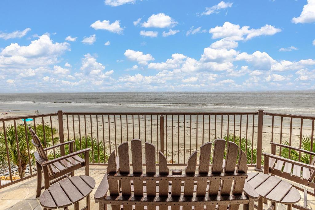 two chairs and a table on a balcony overlooking the beach at Shiphouse 3 - Third Floor in Saint Simons