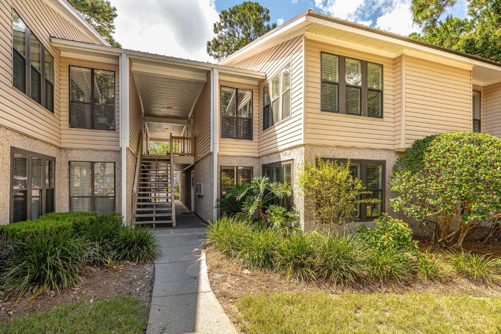 ein großes gelbes Haus mit einer Treppe davor in der Unterkunft Island Retreat #2513-2 in Island Retreat