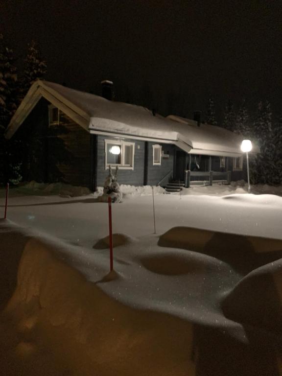 una casa con un cortile coperto di neve di notte di Yllästölli 2 D, Äkäslompolo a Kolari