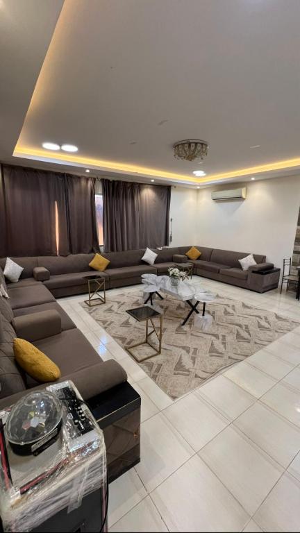 un soggiorno con un divano e un tavolo di شاليه أمسية a Buraydah