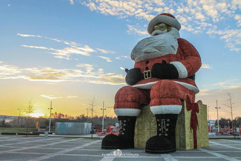 una estatua de un Papá Noel sentado en un banco en Hotel Conde de Agueda, en Águeda