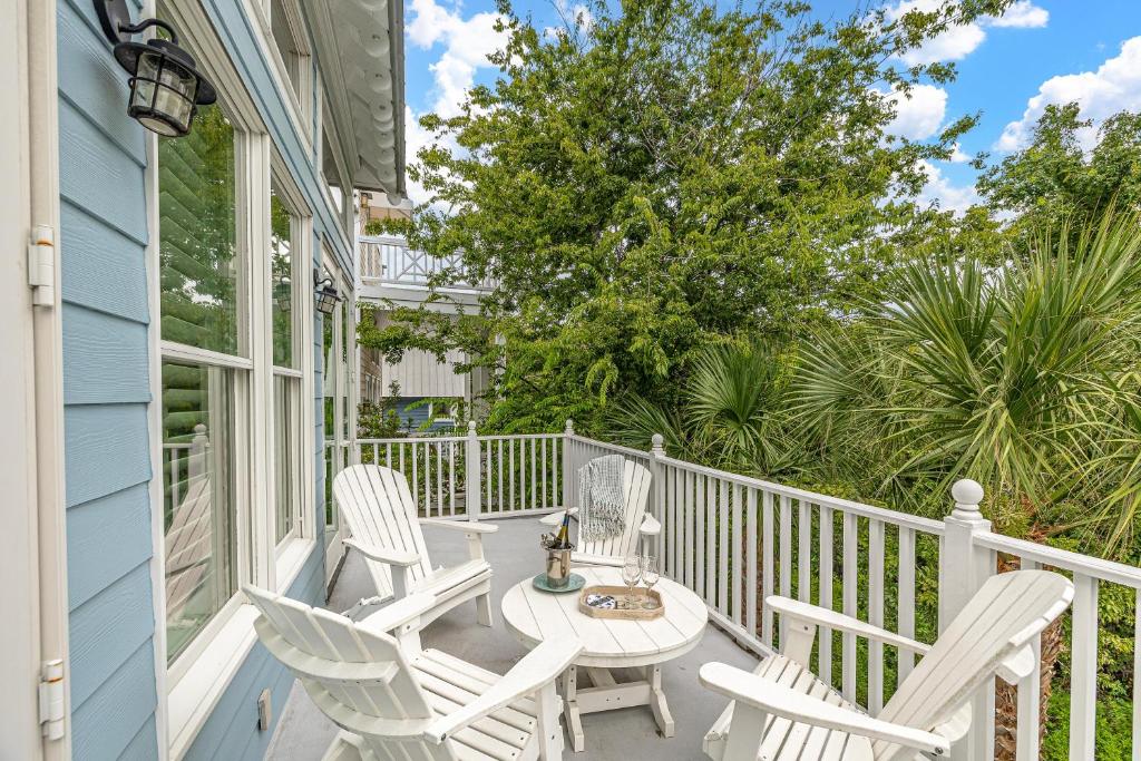 a porch with white chairs and a table at 26 Coast - Shellbar Cottage in East End