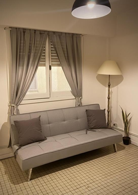 a couch in a living room with a window at Dpto SAN MARTIN in Azul