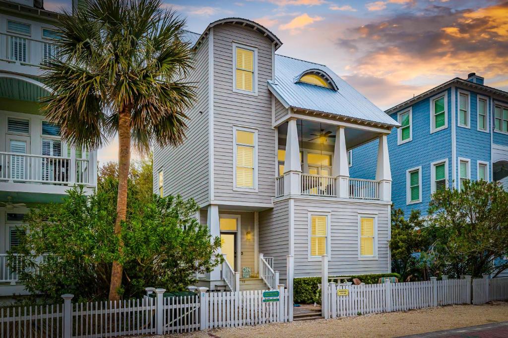 ein Haus mit einem weißen Zaun und einer Palme in der Unterkunft 16 Coast - Merrimac Cottage in East End