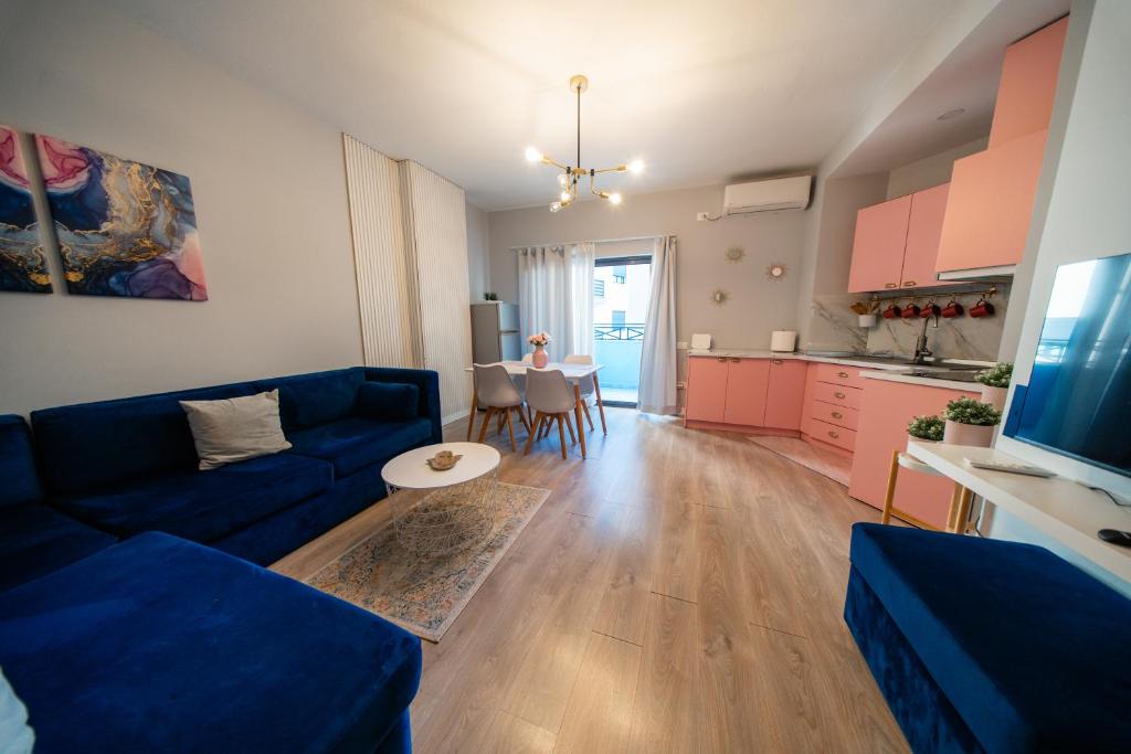 a living room with a blue couch and a kitchen at Central Gem Tirana in Tirana