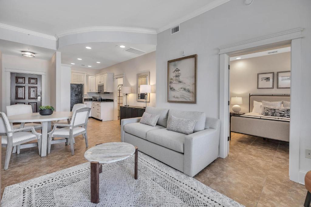een woonkamer met een bank en een tafel en een slaapkamer bij Sea Gate #104 in Demere Park
