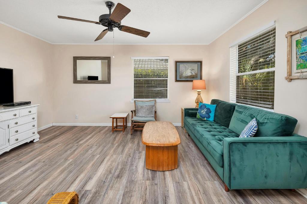 a living room with a green couch and a ceiling fan at 1055 College in Saint Simons Island