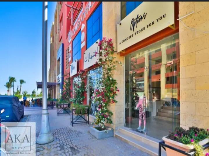 een winkelpui aan een straat met tafels en stoelen bij Luxury Studio, pool, Private beach & close to Airport in Hurghada