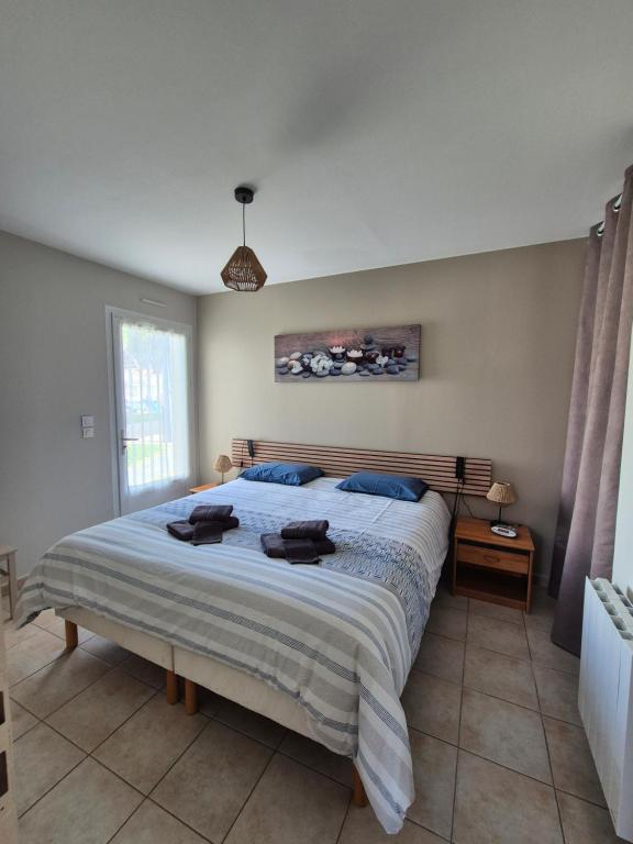 een slaapkamer met een groot bed met handdoeken erop bij Chez Carisa in Puilboreau