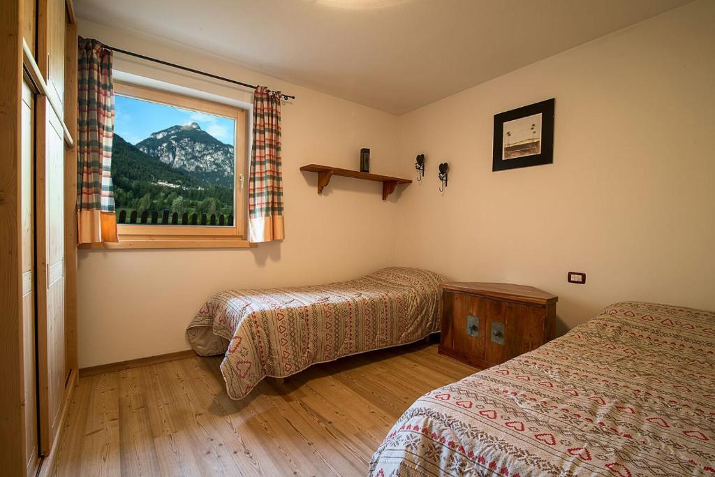 una camera con due letti e una finestra con vista sulle montagne di Casa Fam.Barbolini a Tesero