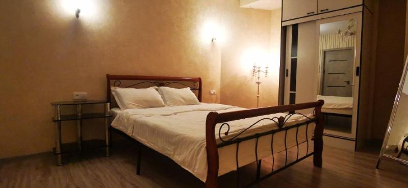 ein Schlafzimmer mit einem großen Bett und einem Nachttisch in der Unterkunft Apartment NEW in Taschkent