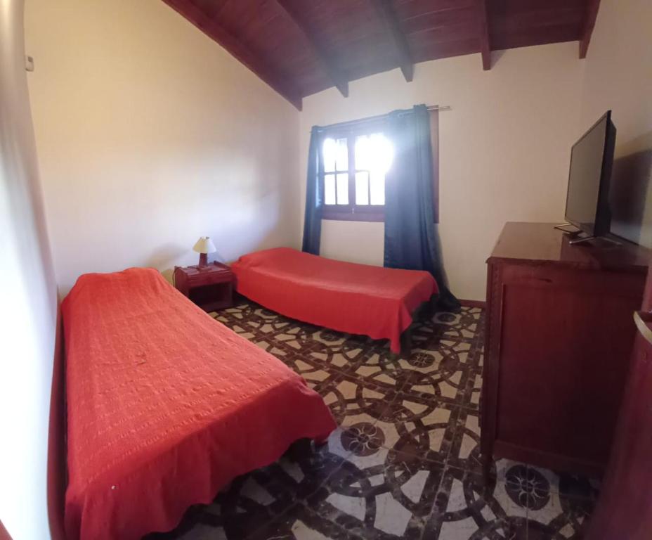 una camera da letto con un letto rosso e una finestra di Cabaña Benitto a Potrero de Garay