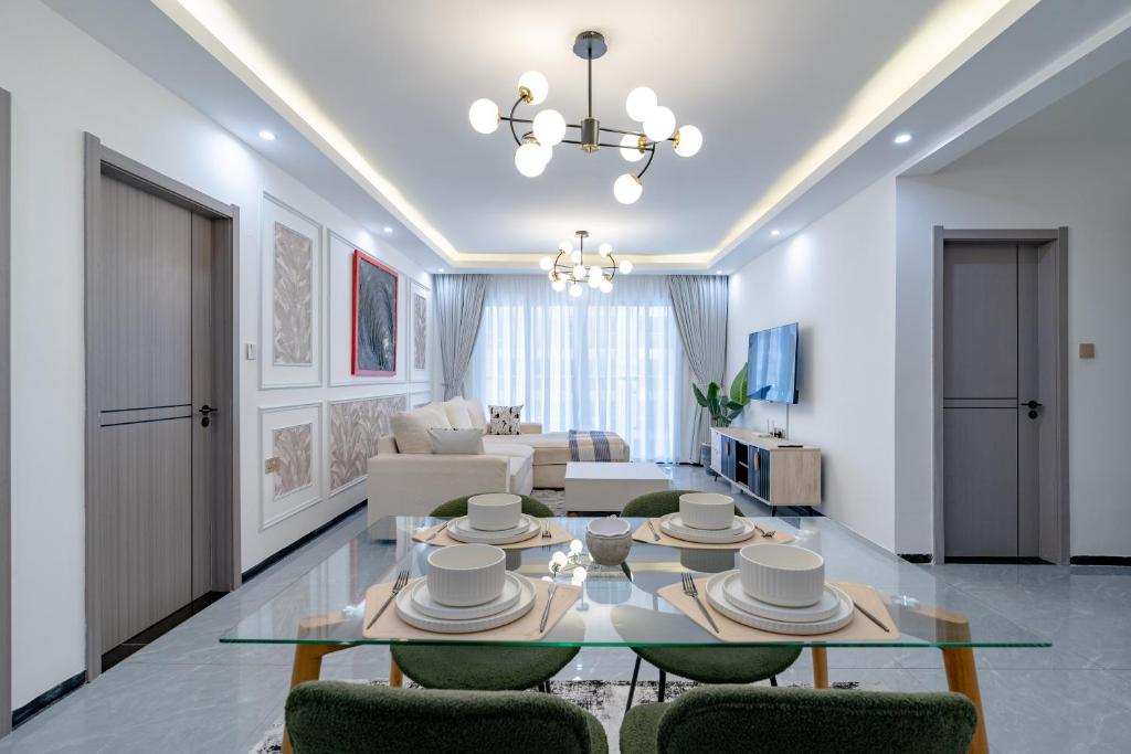 a living room with a glass table and chairs at Tatiana’s Luxury Apartment in Nairobi