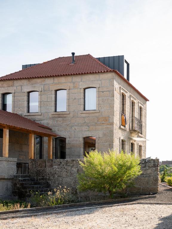 an old stone house with a red roof at Oakstone Hills in Nelas