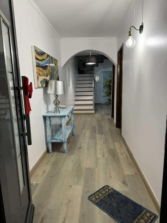 a hallway with a table and a hallway with a staircase at Alvarenga House in Maia