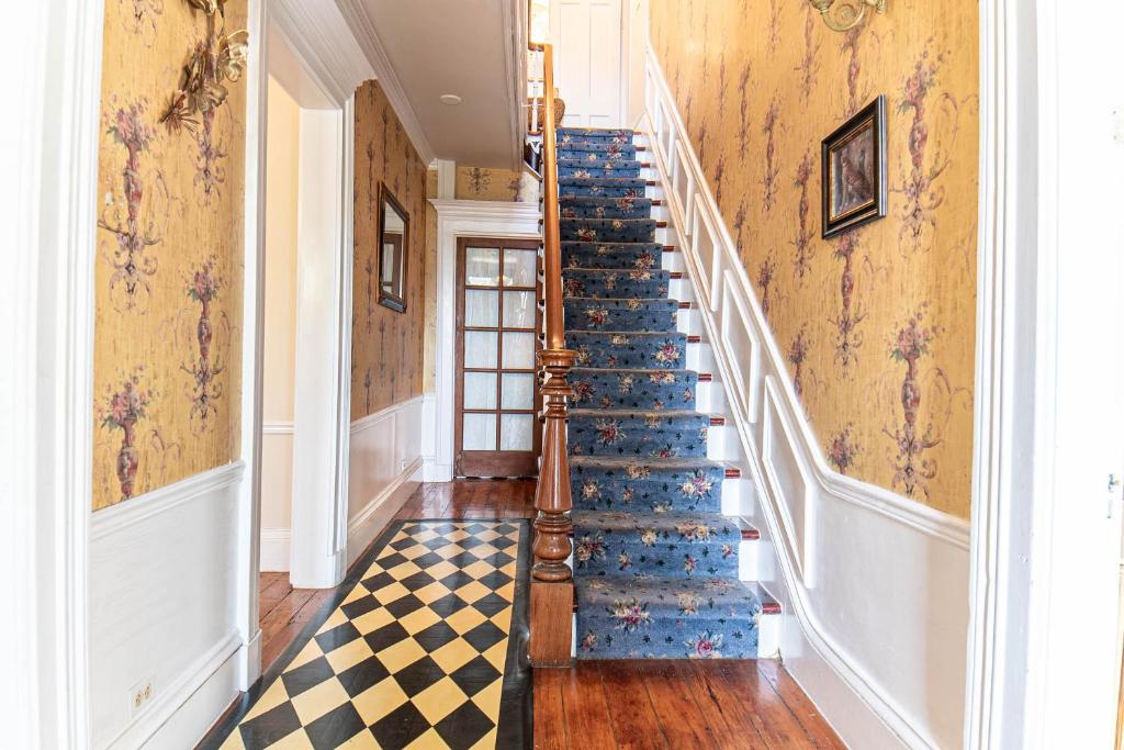 a staircase in a house with a checkered floor at Miss Murphy's High Street Inn in Galena
