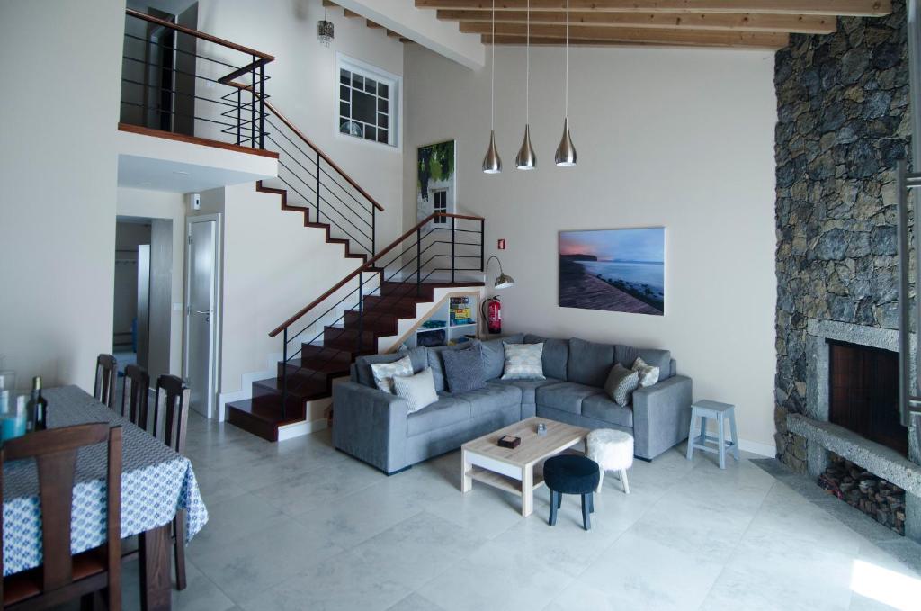 een woonkamer met een bank en een open haard bij Surf Beach_Santa Barbara Secret Gardens in Ribeira Grande