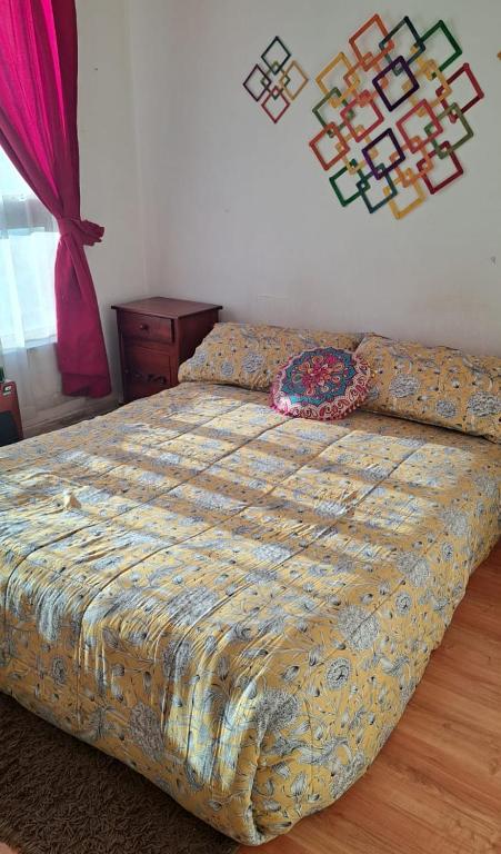 a bed with a comforter on it in a bedroom at Departamento de Vacasiones Viña del Mar 2026 in Viña del Mar