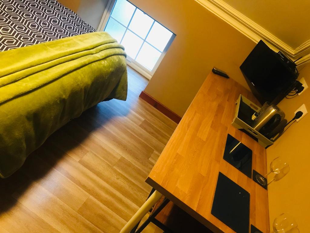 a bedroom with a bed and a wooden table at Pisgah Guesthouse Snowdonia in Blaenau-Ffestiniog