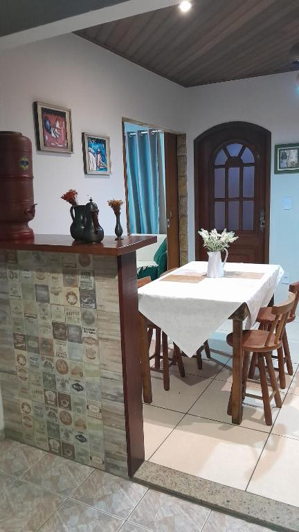 a dining room with a white table and chairs at Natureza e sossego in Volta Redonda