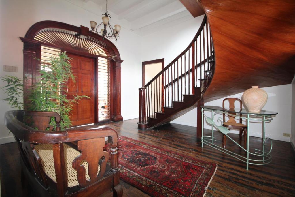 a living room with a staircase and a table and a chair at Mobay Kotch in Montego Bay