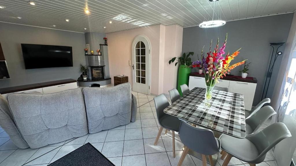 a living room with a table and chairs and a television at Ferienwohnung Nidderau Komfort in Nidderau