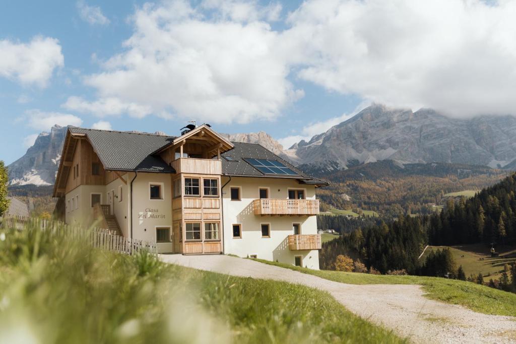 a house on a hill with mountains in the background at Ciasa Bel Marin in La Villa